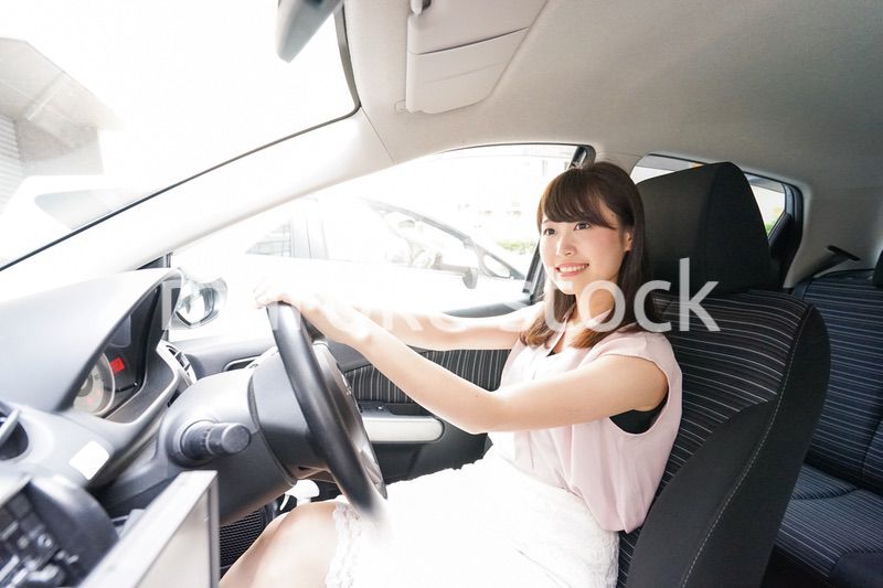 車を運転する若い日本人女性