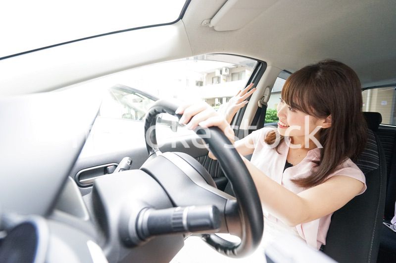 手を振る女性ドライバー