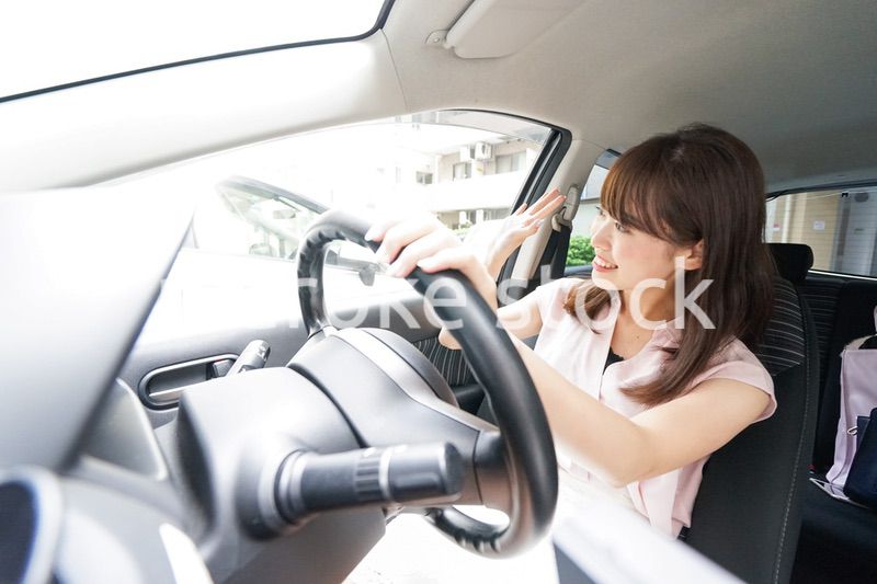 手を振る女性ドライバー