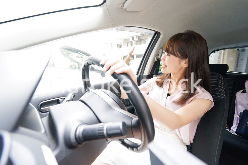 手を振る女性ドライバー