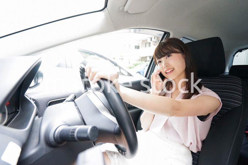 スマホを使いながら運転する女性