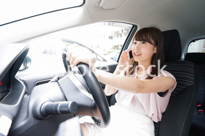 スマホを使いながら運転する女性