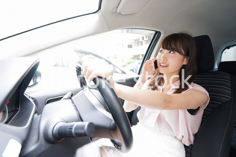 スマホを使いながら運転する女性