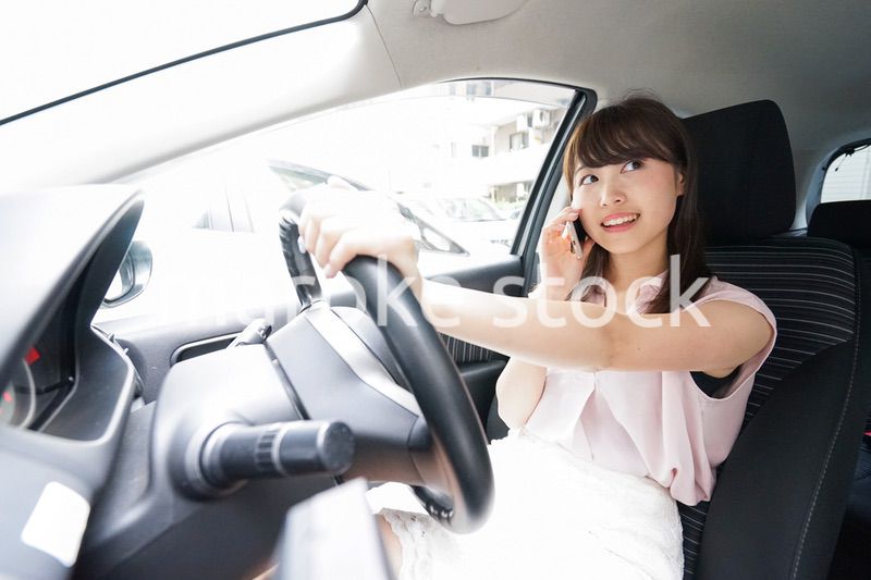 スマホを使いながら運転する女性