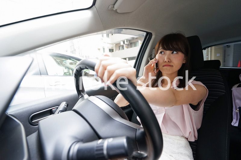 スマホを使いながら運転する女性