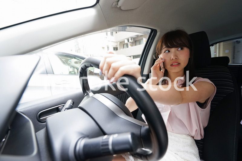 スマホを使いながら運転する女性