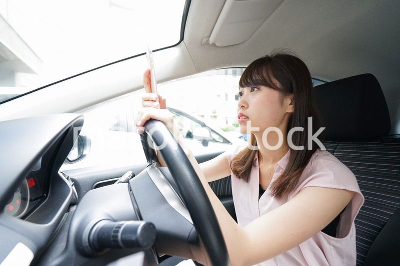 スマホを使いながら運転する女性