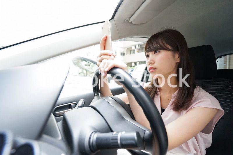スマホを使いながら運転する女性