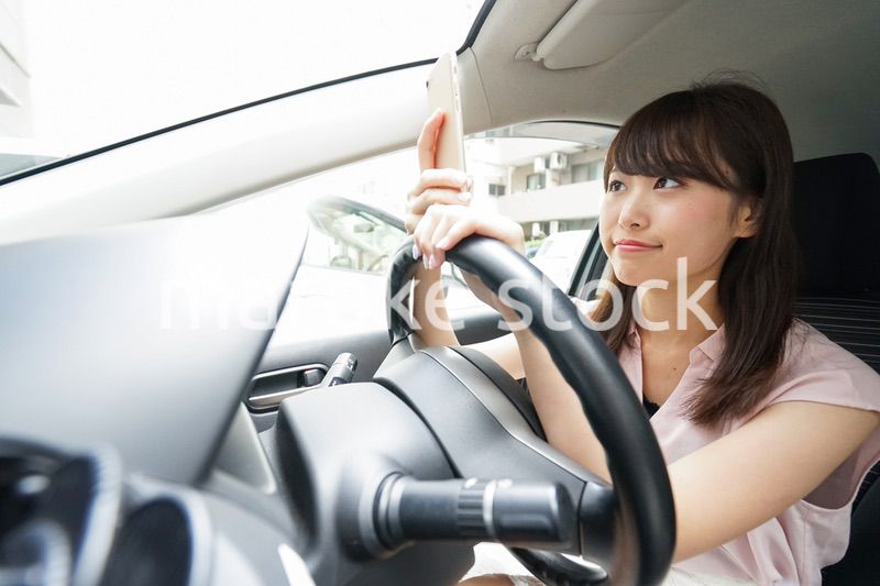 スマホを使いながら運転する女性