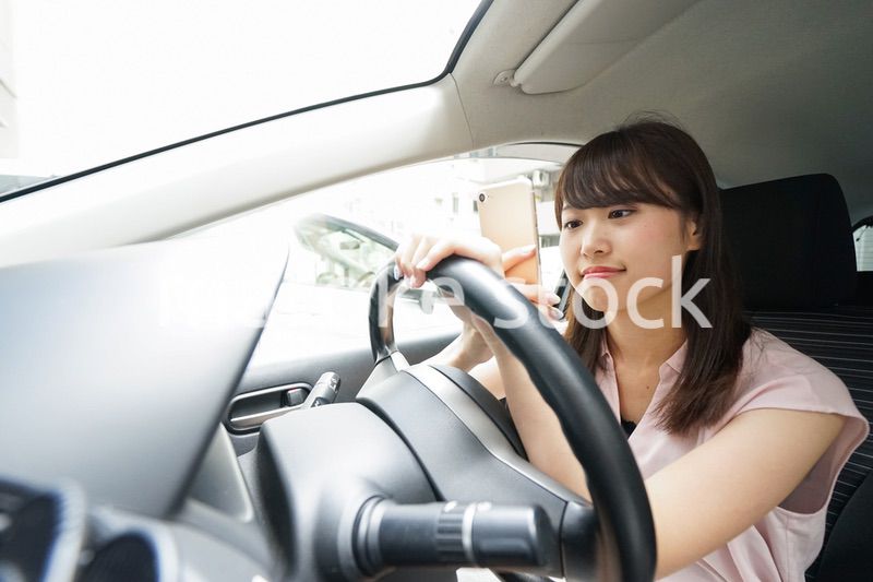 スマホを使いながら運転する女性