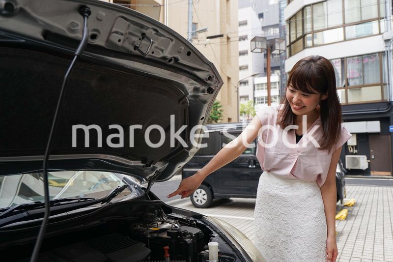 車のメンテナンスをする女性