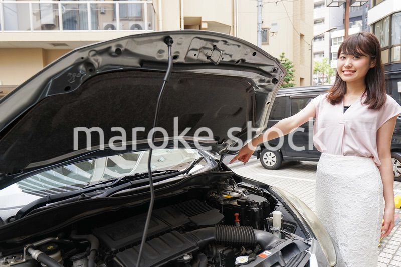 車のメンテナンスをする女性