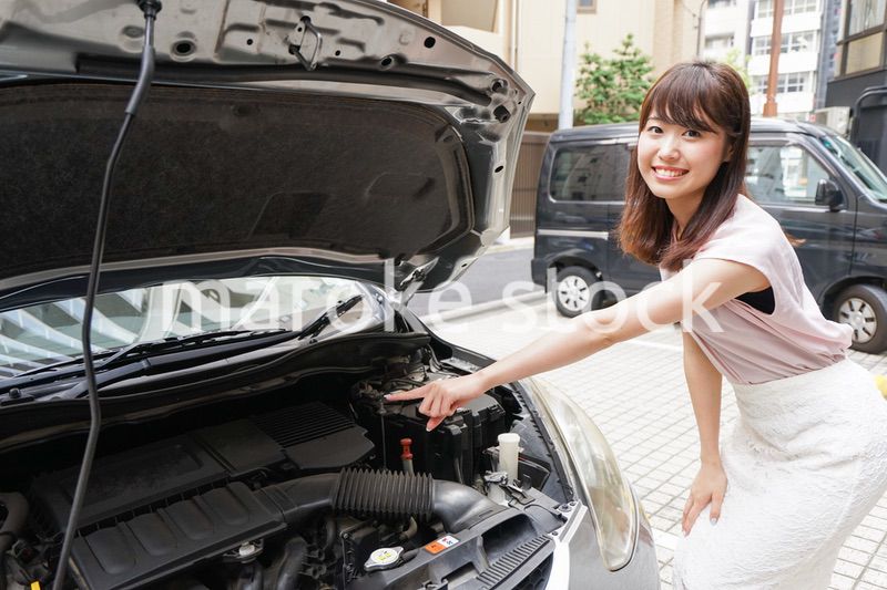 車のメンテナンスをする女性