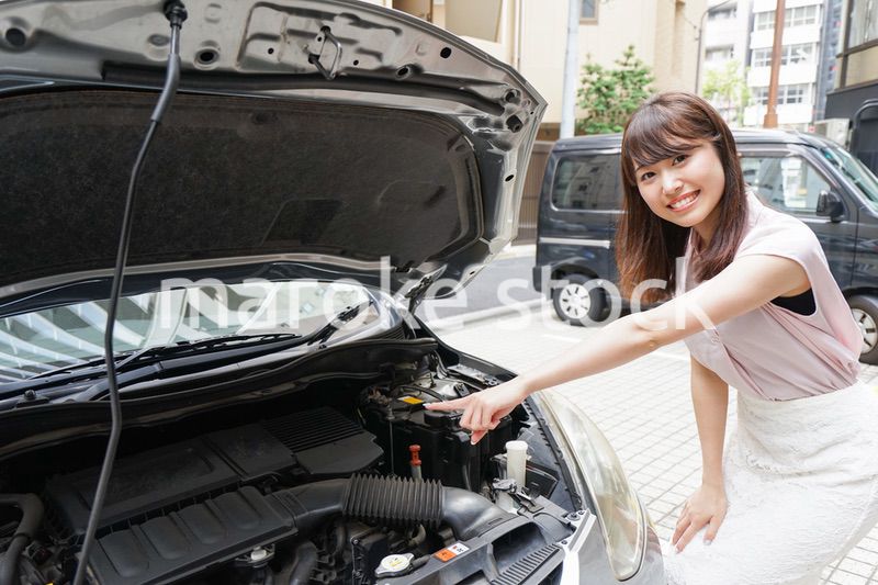 車のメンテナンスをする女性