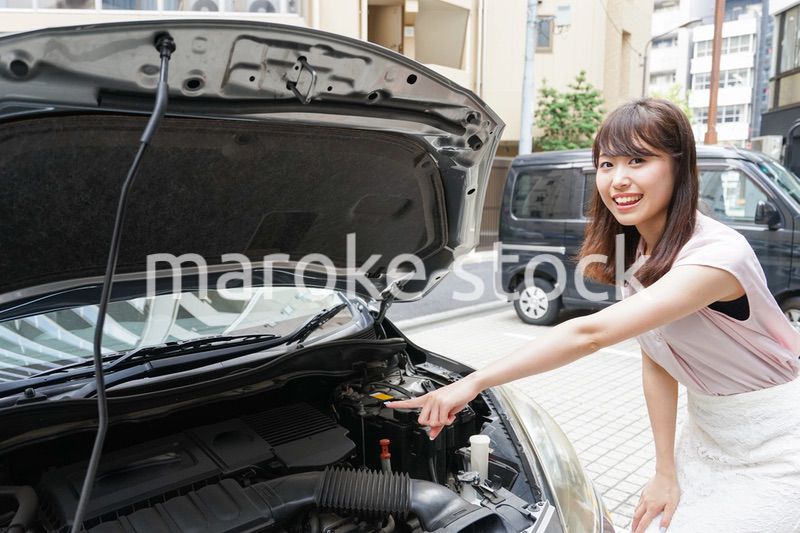 車のメンテナンスをする女性