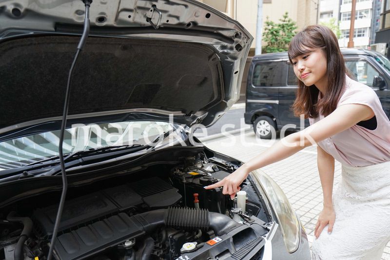 車のメンテナンスをする女性