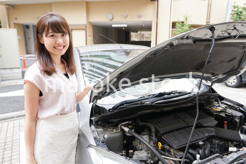 車のメンテナンスをする女性