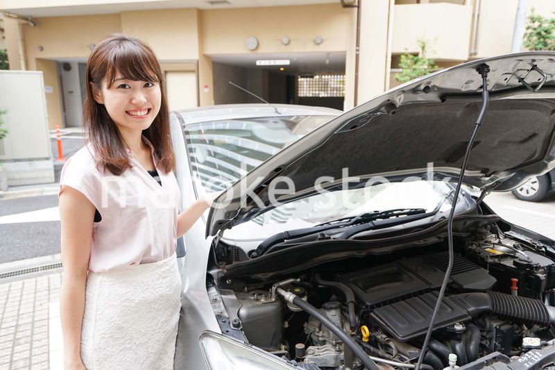 車のメンテナンスをする女性
