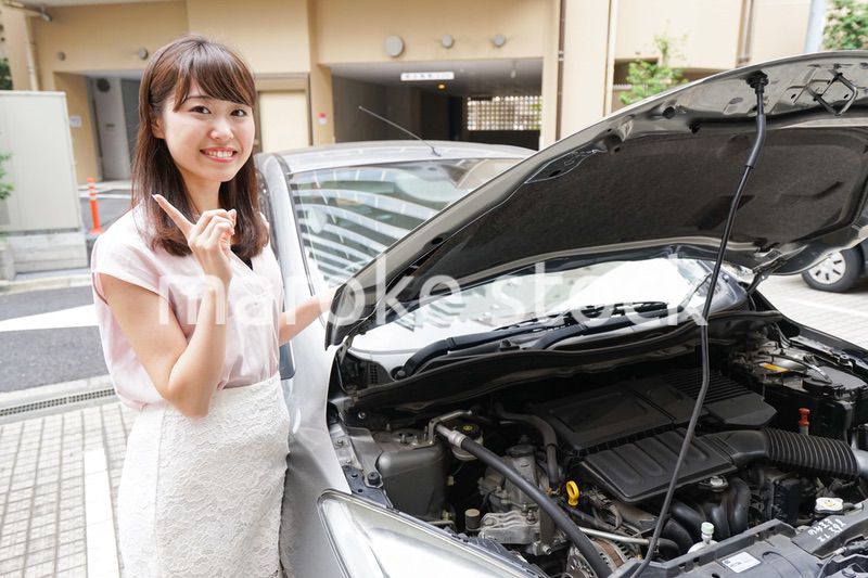 車のメンテナンスをする女性