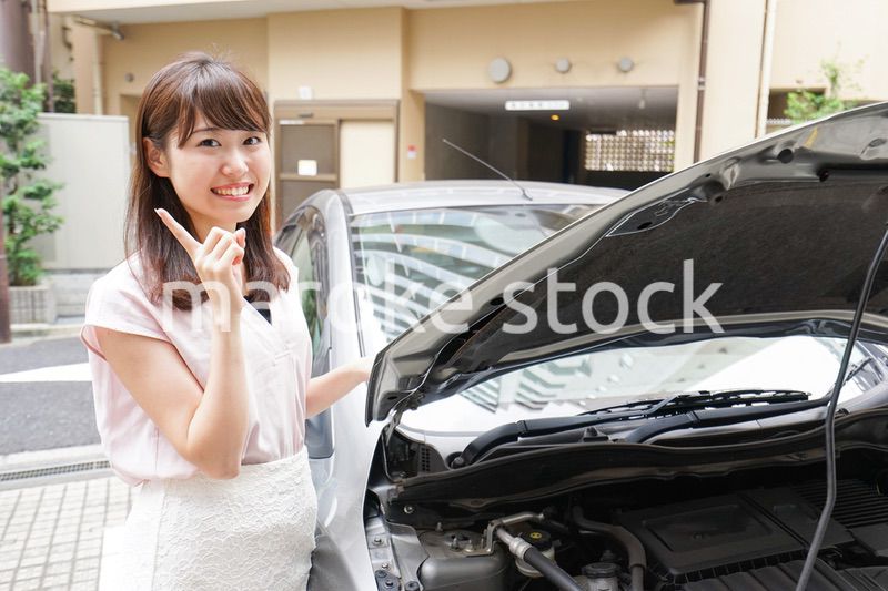 車のメンテナンスをする女性