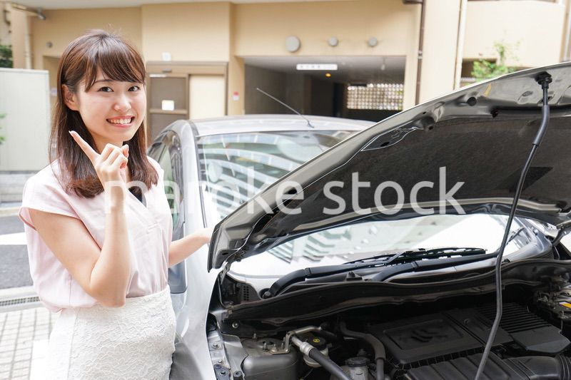 車のメンテナンスをする女性