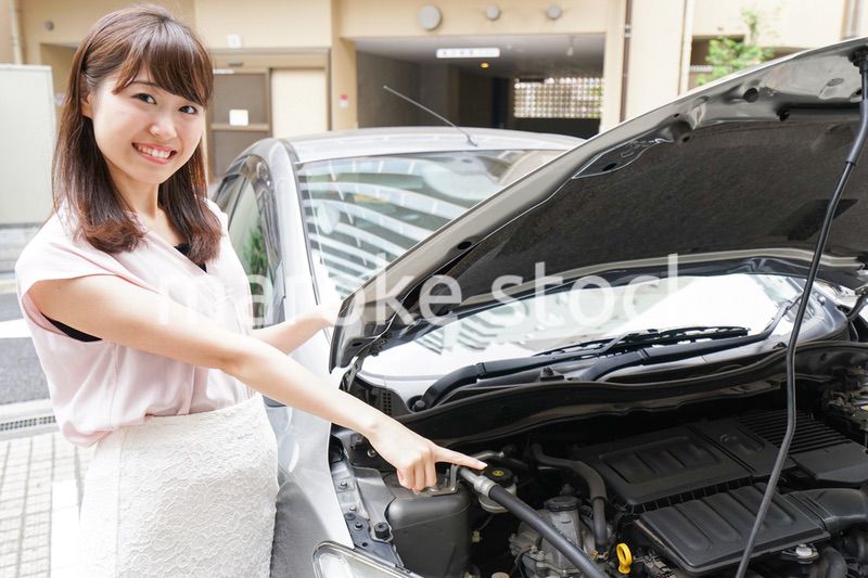 車のメンテナンスをする女性