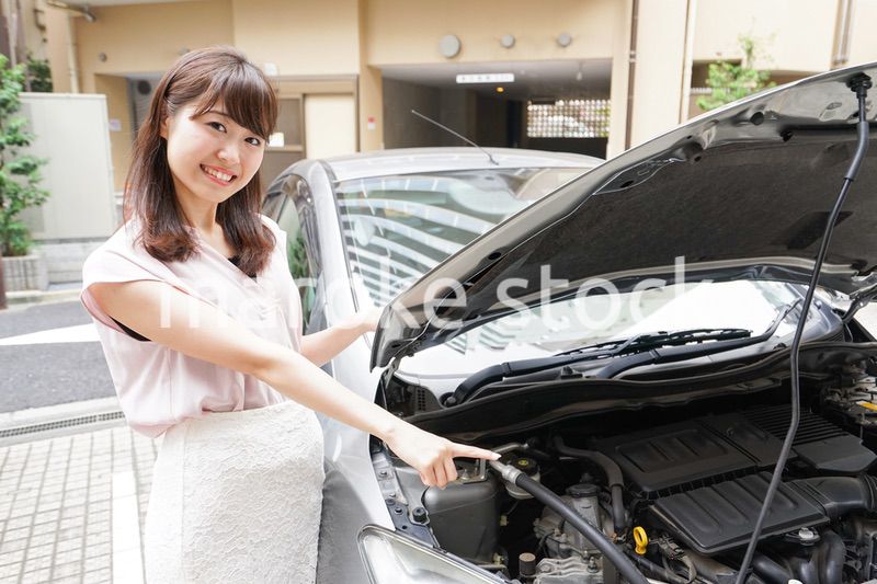 車のメンテナンスをする女性