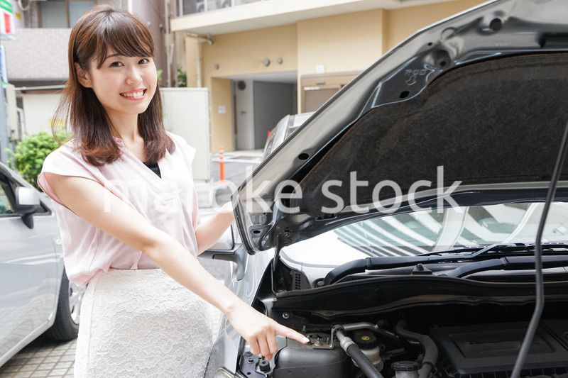 車のメンテナンスをする女性