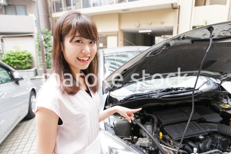 車のメンテナンスをする女性