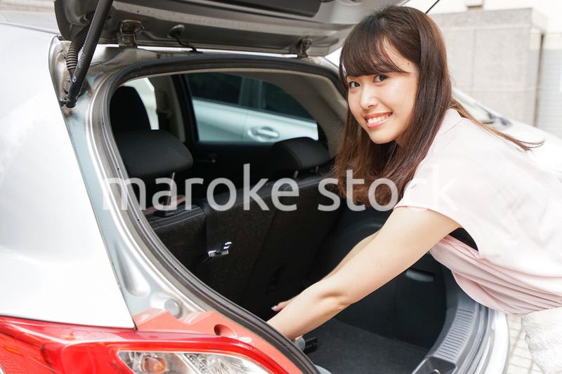 車のトランクを開ける女性