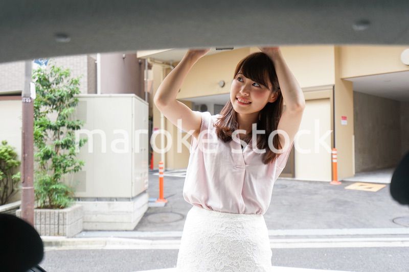 車のトランクを開ける女性