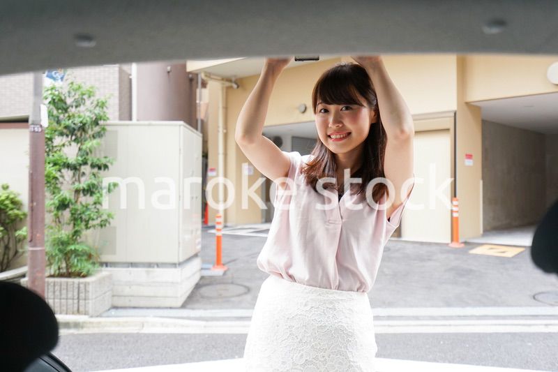 車のトランクを開ける女性