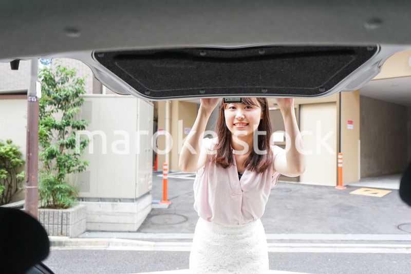車のトランクを開ける女性