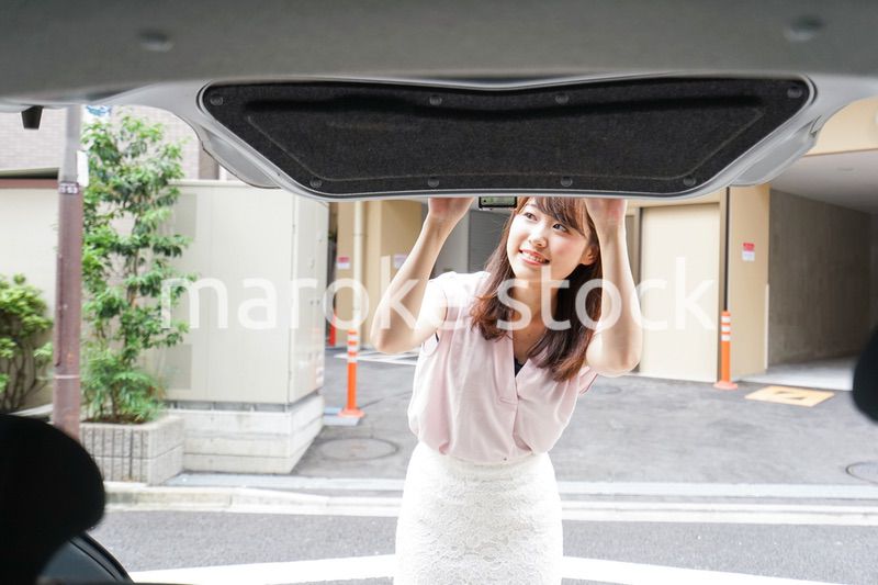 車のトランクを開ける女性