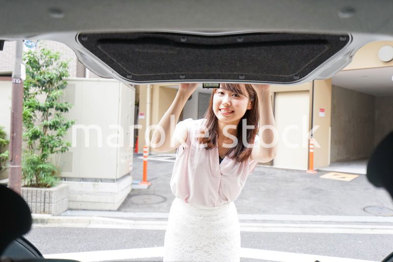 車のトランクを開ける女性