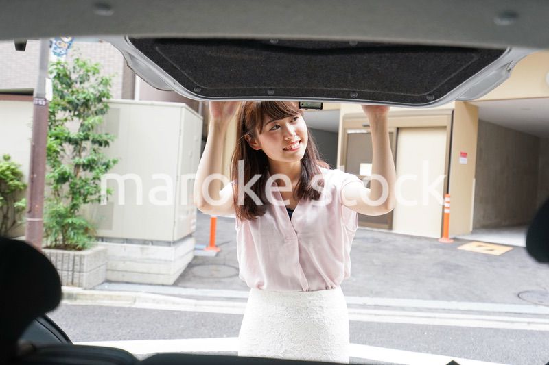 車のトランクを開ける女性