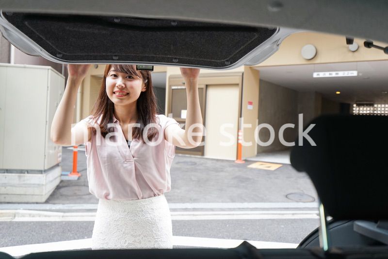 車のトランクを開ける女性