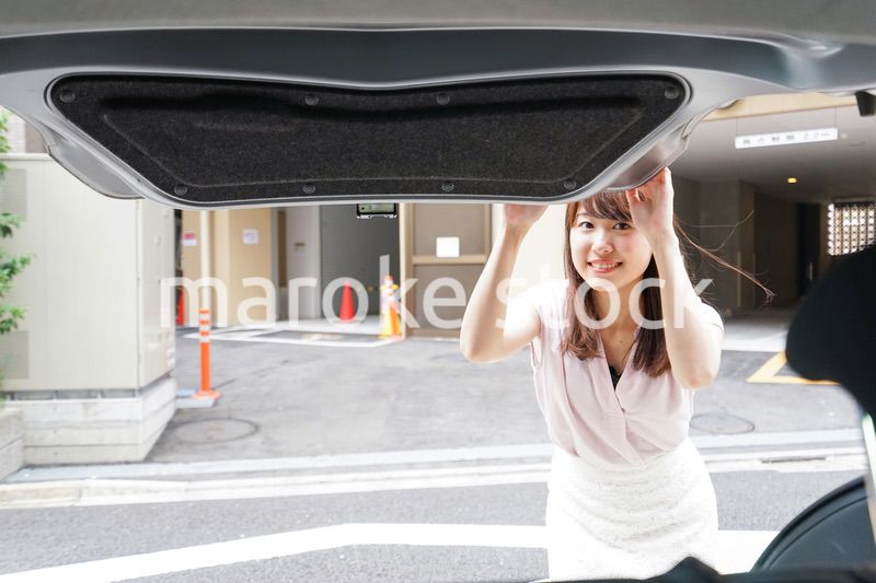 車のトランクを開ける女性