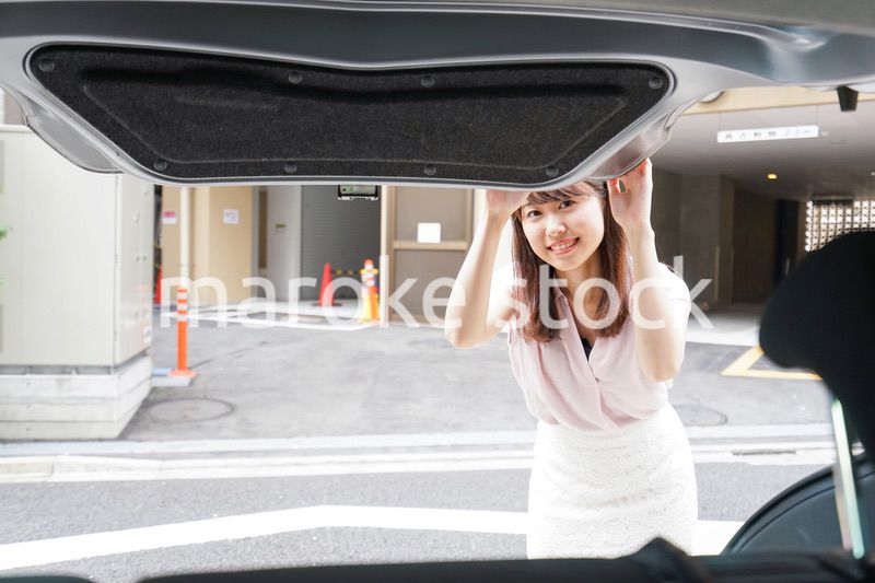 車のトランクを開ける女性