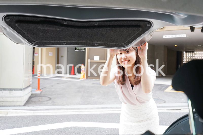車のトランクを開ける女性