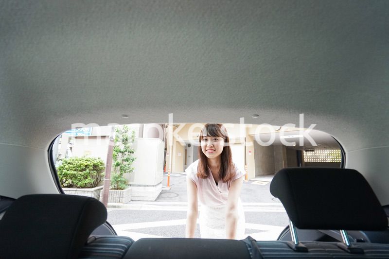 車のトランクを開ける女性