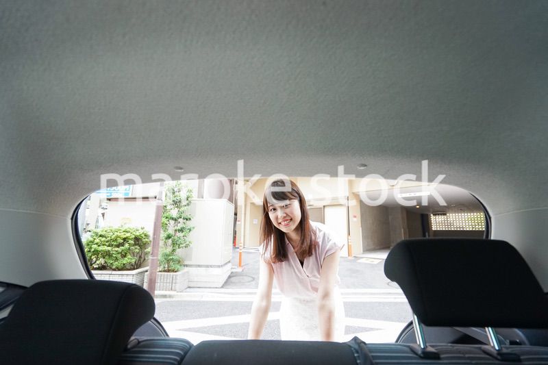 車のトランクを開ける女性