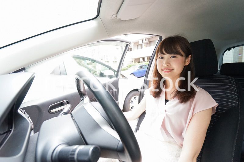 車を運転する若い日本人女性