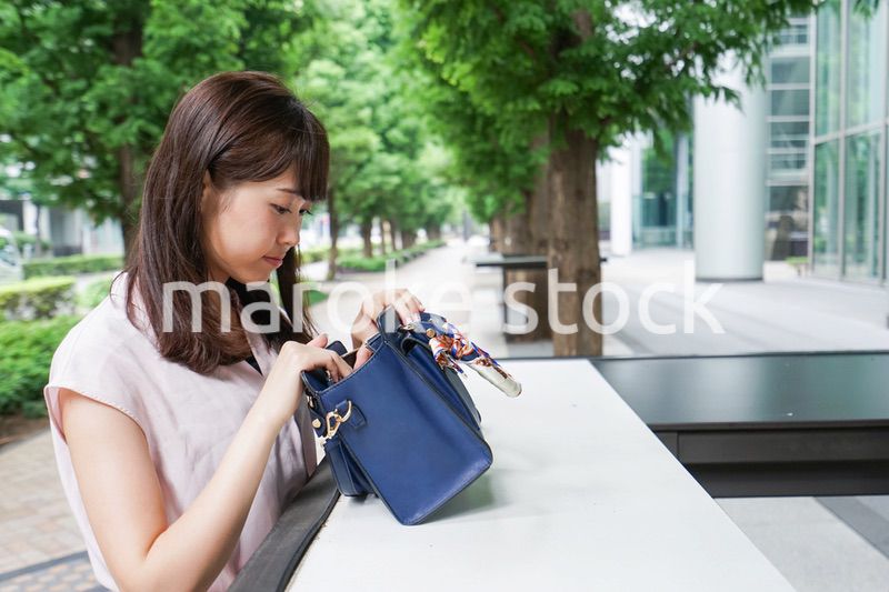 カバンを見る若い女性
