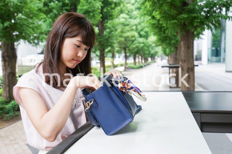 カバンを見る若い女性