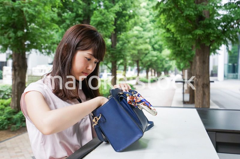 カバンを見る若い女性
