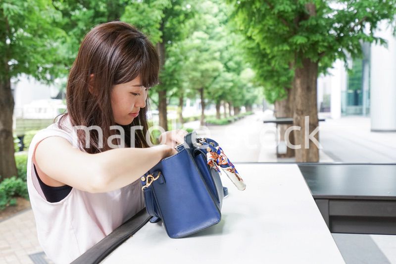 カバンを見る若い女性