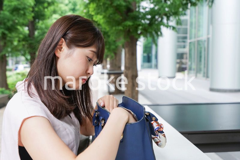 カバンを見る若い女性