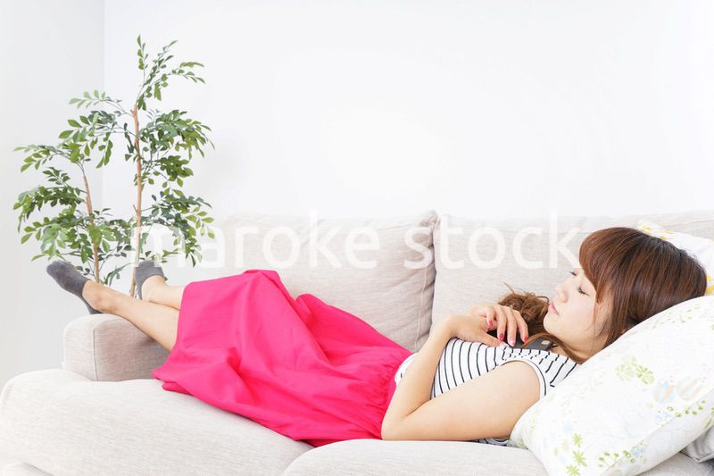 ソファで寝る若い女性