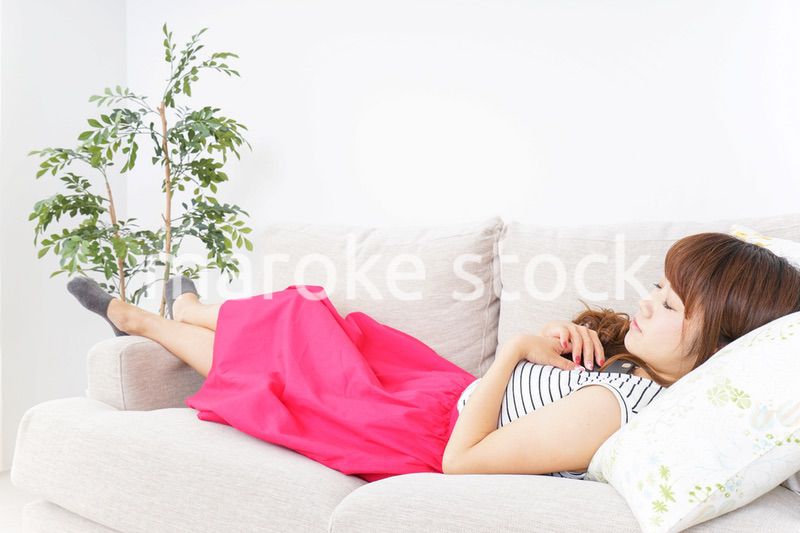 ソファで寝る若い女性